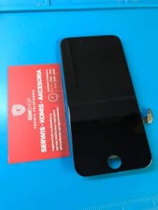 Nowy czarny moduł wyświetlacza do telefonu na macie serwisowej obok wizytówki GSMSHOP